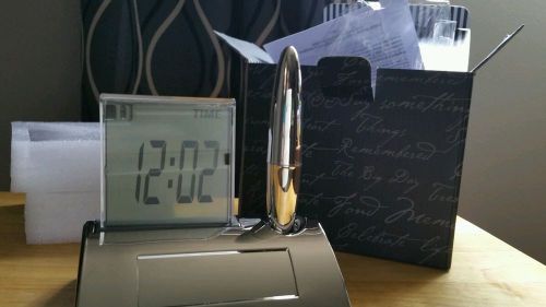 Gravity desk clock with pen